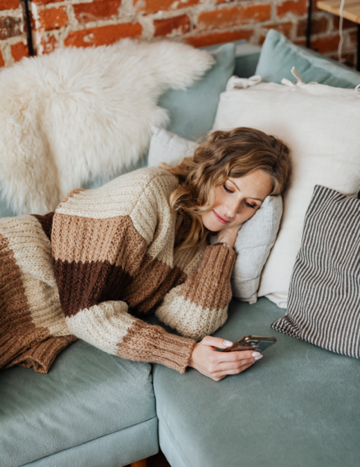 woman using her phone on a couch