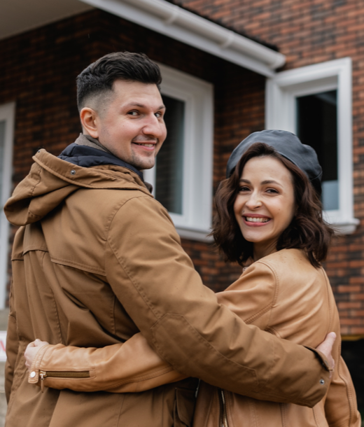 Couple smiling in front of a house in Ottawa